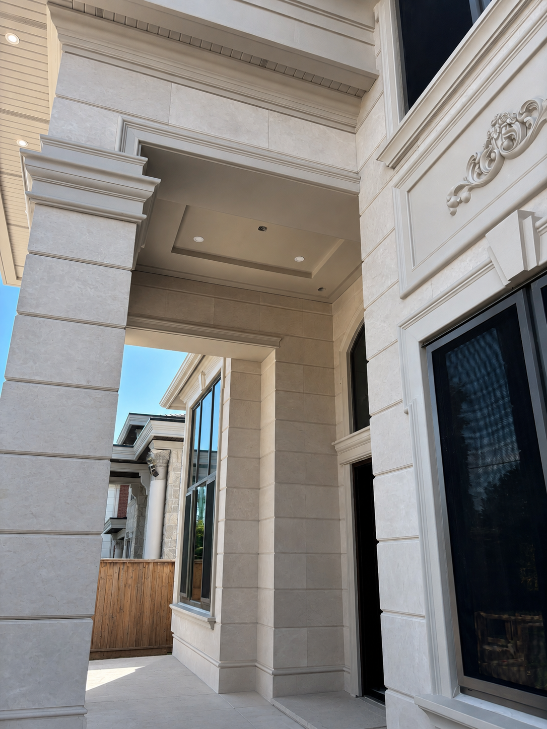 Light limestone exterior cladding with carved columns and ornate window surrounds